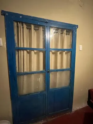 a blue door with curtains in a room at Habitación con recojo desde el aereopuerto in Cusco
