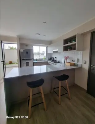 a kitchen with two bar stools and a counter top at María Paz Home in Lima