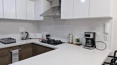 a kitchen with white cabinets and a stove top oven at Departamento en Barranco - Like at Home in Lima