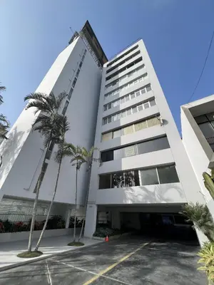 a building with palm trees in front of it at Av arequipa 603B in Lima