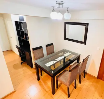 a dining room with a glass table and chairs at Apartamento en Santiago de Surco in Lima