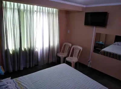 a bedroom with two chairs and a bed and a television at Francisco D Francisco in Lima
