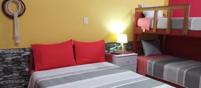 a bedroom with two bunk beds with red pillows at Departamento con Cochera gratuita dentro de Instalaciones 8p Tierra del Sol Eterno Ica centro in Ica
