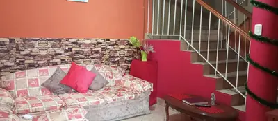 a living room with a couch with pink pillows at Departamento con Cochera gratuita dentro de Instalaciones 8p Tierra del Sol Eterno Ica centro in Ica