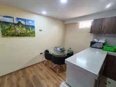 a kitchen with a counter and a table in a room at Departamento en La casa de Teresita in Cusco