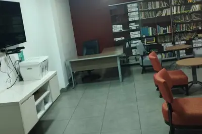 a library with a desk and chairs and a table at Private Apartament in LINCE near MIRAFLORES & REBAGLIATI HOSPITAL with POOL, GYM, PRIVATE PARK ! in Lima