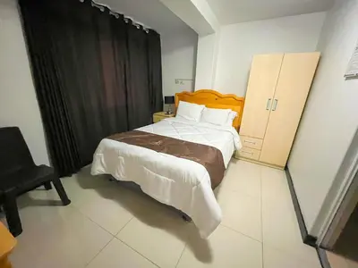 a bedroom with a large bed and a cabinet at Hotel Orlak in Huancayo
