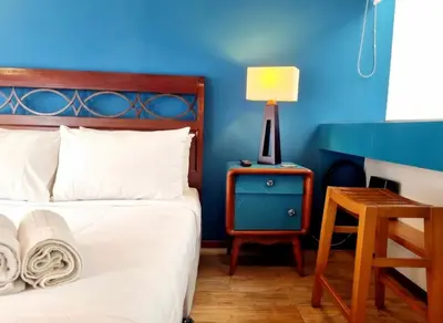 a blue bedroom with a bed and a table with a lamp at E SuiteTOP Tudela San Isidro Lima 2B 202 in Lima