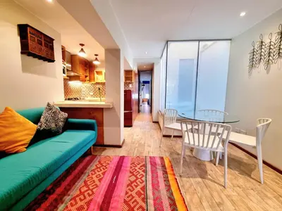 a living room with a green couch and a glass table at E SuiteTOP Tudela San Isidro Lima 2B 202 in Lima