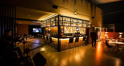 a bar in a restaurant with a person walking into it at Wyndham Costa del Sol Lima City in Lima