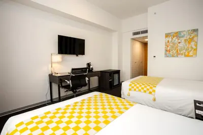 a hotel room with two beds and a desk and a tv at Wyndham Costa del Sol Lima City in Lima