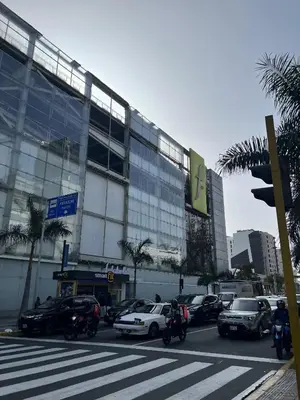 a parking lot with cars and motorcycles in front of a building at Wonderful apartment Miraflores Kennedy 603A in Lima