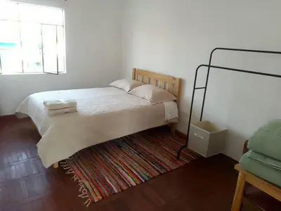 a bedroom with a bed with a rug and a window at Kasa-4 B&B Family Home in Huancayo