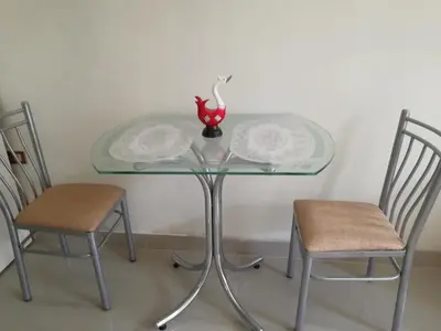 a glass table with two chairs and a vase on it at ESTUDIO COMPLETO en el CENTRO HISTORICO de LIMA in Lima