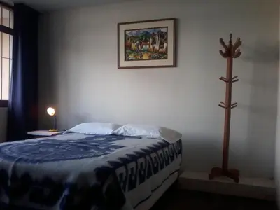 a bedroom with a bed and a cross on the wall at Royal Sweet Dreams Airport B&B in Lima