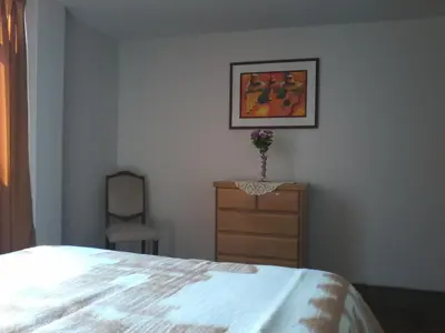a bedroom with a bed and a dresser and a picture at Royal Sweet Dreams Airport B&B in Lima
