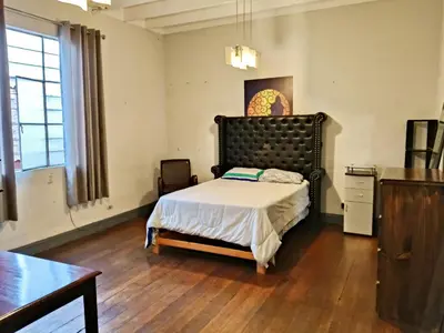 a bedroom with a bed with a black headboard at Casa Turística Monumental in Lima