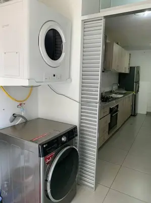 a kitchen with a washing machine and a microwave at Departamento de 04 dormitorios in Lima