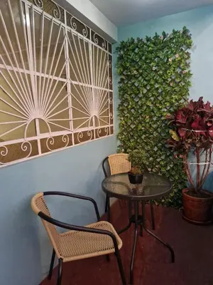 a table and chairs in a room with a green wall at Apartamento-Santa Anita, Villa Caly in Lima