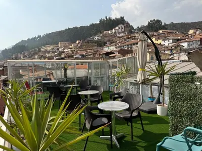 a patio with tables and chairs on a roof at Hotel Plateros in Cusco
