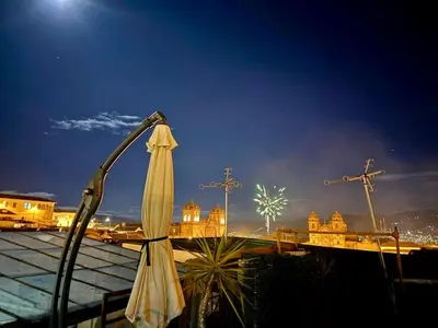 a closed umbrella and some crosses in the background at Hotel Plateros in Cusco