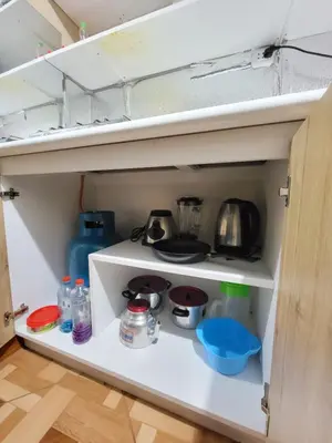 an open cupboard in a small kitchen with a kitchen at Departamento, LUJO HOGAR cerca a PLAZA NORTE - UNI AEROPUERTO in Lima