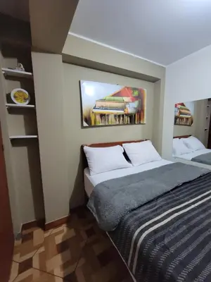 a bedroom with a bed and a painting on the wall at Departamento, LUJO HOGAR cerca a PLAZA NORTE - UNI AEROPUERTO in Lima