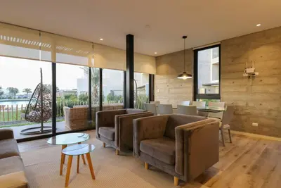 a living room with couches and a table and a kitchen at Aldea 3BR Chic Bay Hideaway in Paracas