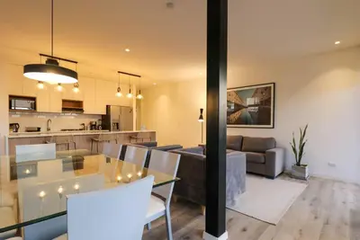 a living room and kitchen with a glass table and a couch at Aldea 3BR Chic Bay Hideaway in Paracas