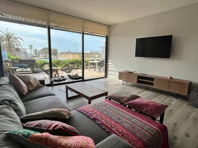 a living room with a couch and a flat screen tv at 2BR Spacious Ground Level with Gym Pool and Cowork in Paracas