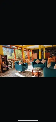 a living room with blue couches and a table at SARA GARDEN LODGE Ollantaytambo in Ollantaytambo