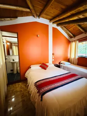 a bedroom with orange walls and a large bed at SARA GARDEN LODGE Ollantaytambo in Ollantaytambo