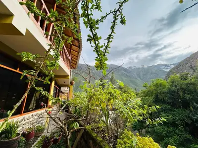 a building with a view of the mountains at SARA GARDEN LODGE Ollantaytambo in Ollantaytambo