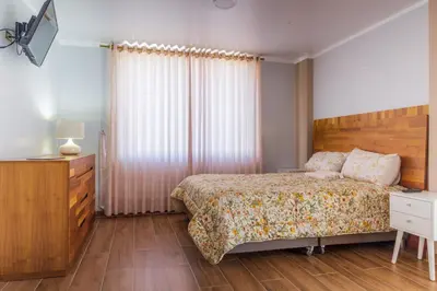 a bedroom with a bed with a wooden headboard at Villa San Ramon - BIG HOUSE - Chamchamayo in San Ramón