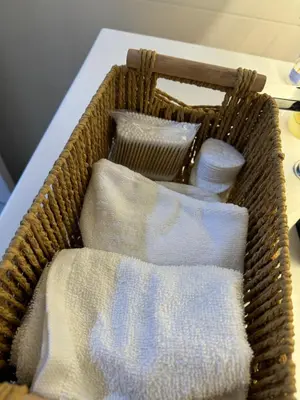 a basket filled with white towels on a table at Cómodo y Acogedor Departamento Cerca de Barranco y el Circuito de Playas in Lima
