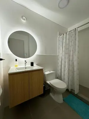 a bathroom with a toilet and a sink and a mirror at Cómodo y Acogedor Departamento Cerca de Barranco y el Circuito de Playas in Lima