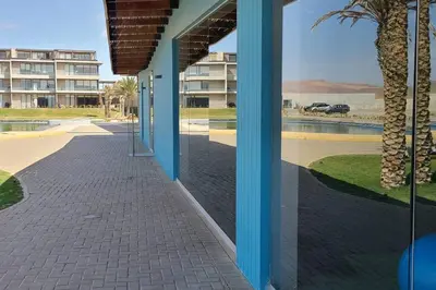 a building with a view of a street and a palm tree at Aldea 1BR Penthouse wtih Private Pool and Views for 2 in Paracas