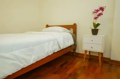 a bedroom with a bed with a plant on a night stand at Bello Familiar Miraflores Larcomar Kennedy in Lima