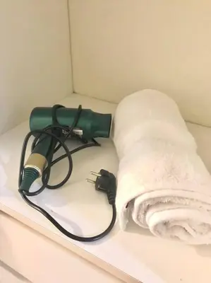 a green blow dryer and a towel on a shelf at Bello Familiar Miraflores Larcomar Kennedy in Lima
