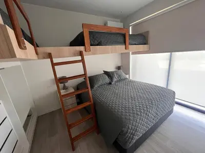 a bedroom with two bunk beds and a ladder at Aldea 2BR TVs, KamadoBBQ for 6, Gym,Pool and Cowork in Paracas
