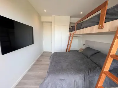 a bedroom with a bed and a tv and bunk beds at Aldea 2BR, Service Room and Ocean View for 7 in Paracas