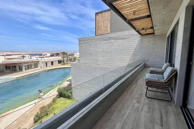a balcony with a chair and a view of the water at Aldea 2BR Ocean View and Kamado BBQ for 6 in Paracas