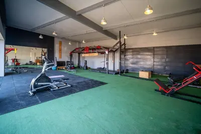 a gym with exercise equipment and green carpet at Aldea 3 Bedroom Terrace Escape with Service Room in Paracas