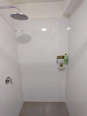 a bathroom with a white wall with a light on it at Departamento Amoblado en Lince in Lima