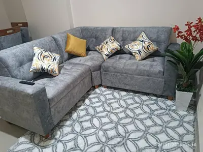 a gray couch with pillows on it in a living room at MarsHouse in Chirimoyo