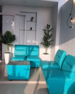 a room with blue chairs and a table and plants at MarsHouse in Chirimoyo