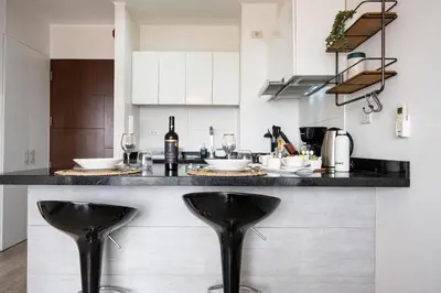 a kitchen with two black stools at a counter at Connect Apartment by Vibrant in Lima