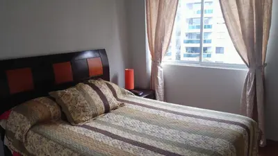 a bed in a bedroom with a window and a bedspread at Residencial Pardo in Lima