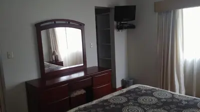 a bedroom with a dresser with a mirror and a bed at Residencial Pardo in Lima