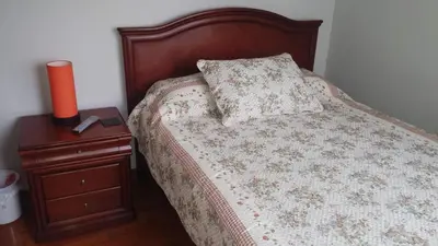 a bed with a pillow and a candle on a night stand at Residencial Pardo in Lima